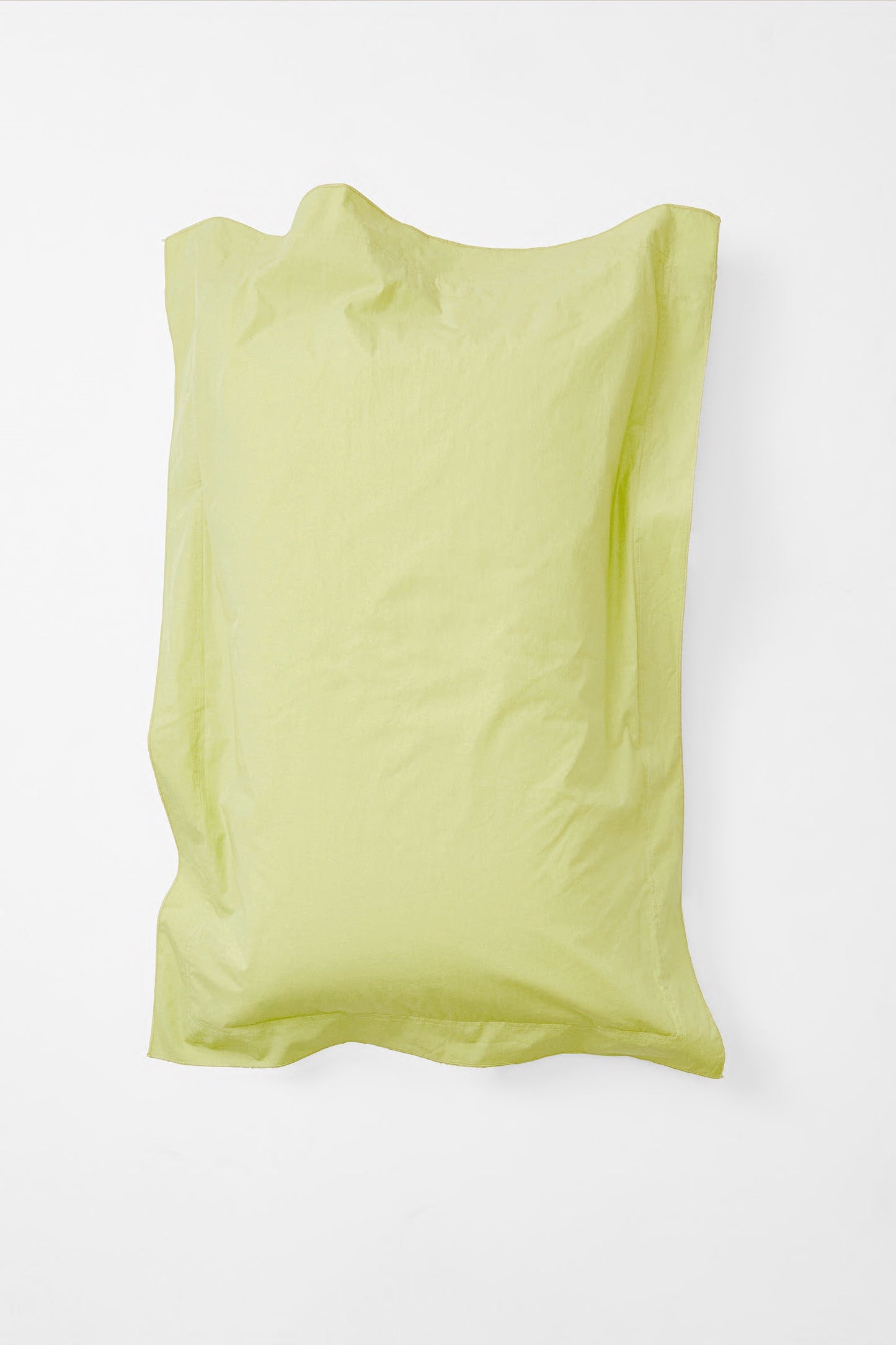 Aerial view of single 'sulphur' coloured pillow with lightly ruffled edges.